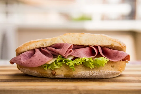 Ham sandwich on a wooden surface — Stock Photo, Image