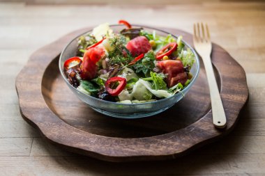 Taze salata domates ve zeytinyağı bir ahşap yüzeye.