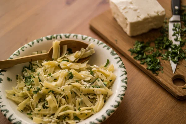 Turkish Noodle / Eriste with cheese and parsley on a wooden surface. — Stock Image Turkish Noodle / Eriste with cheese and parsley on a wooden surface. Stock Photo