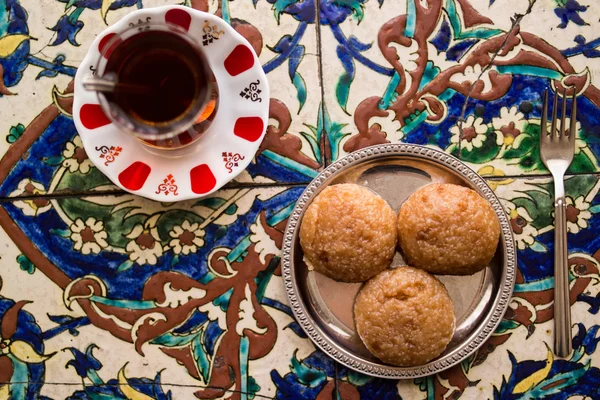 Turkish Dessert Kemalpasa with Tea on a Ottoman Pattern Surface. — Stock Photo, Image