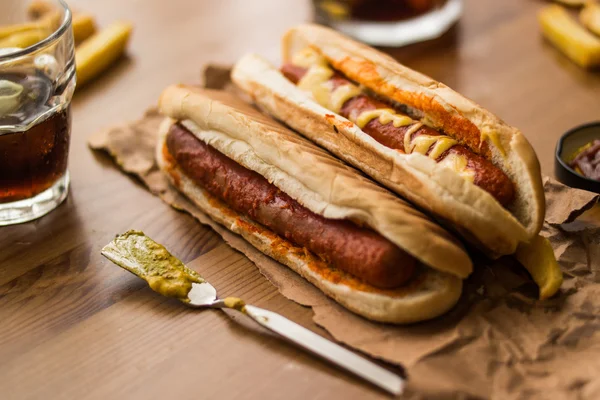 Sanduíche de cachorro quente com mostarda amarela, bebida e batatas . — Fotografia de Stock