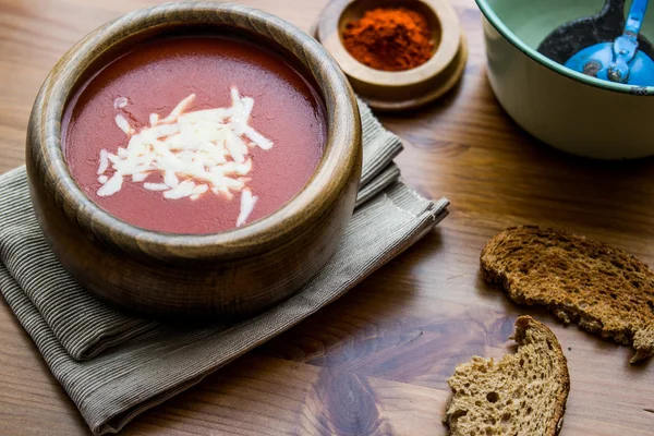 Tomatensoep met kaas op een houten ondergrond — Stockfoto