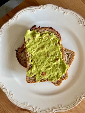 Püre Avokado sosu ya da Püre Guacamole ve Tost Ekmeği Tabakta Kahvaltı. Organik Sağlıklı Yemek.