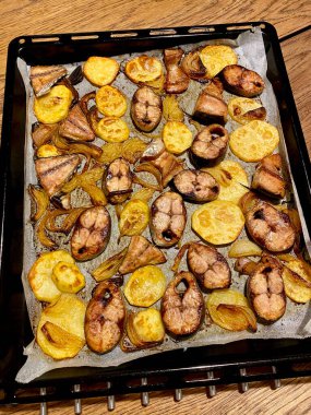 Tavayla fırında pişirilmiş Bonito Balık Parçaları ve Patates Fırını. Tepside Parşömen Kağıdı. Yemeye hazır..