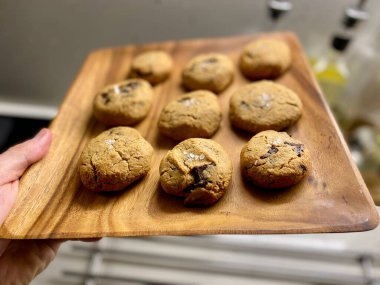 Tahta tabakta Hindistan cevizi ve badem unundan yapılmış Paleo çikolatalı kurabiye. Erimiş Çikolatalı Organik Tatlı.