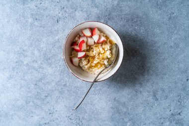 Elma dilimleri ve ballı yulaf lapası kasesi. Organik Sağlıklı Yemek.