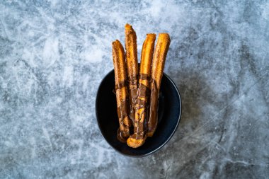 Çikolata soslu Churros Sosu. Kızarmış Hamur Pastası Geleneksel İspanyolca veya Meksika Tatlısı. Hizmet ve Yemeye Hazır.