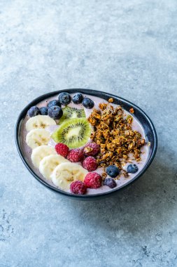 Fırında granola, yabanmersini, ahududu, muz ve kivi ile Acai Smoothie Bowl. Hizmet ve Yemeye Hazır.