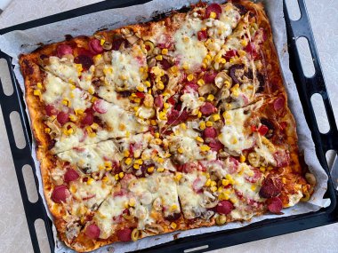 Biberli, Mozzarella peynirli, sosisli ve mısırlı ev yapımı taze pişmiş pizza. Yemeye hazır..