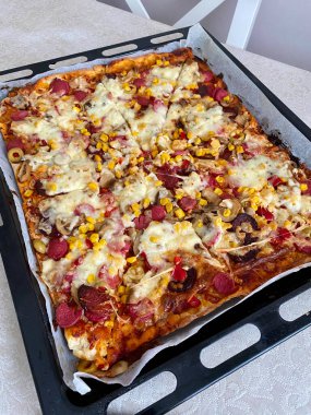 Biberli, Mozzarella peynirli, sosisli ve mısırlı ev yapımı taze pişmiş pizza. Yemeye hazır..