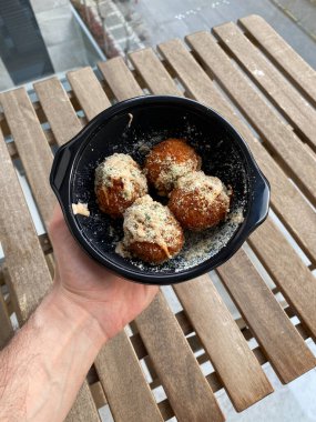 Kızarmış peynirli makarna ve peynirli topları plastik tabak kutusunda parmesan peynirli makarna ısırığıyla götür. El ele tutuşmak. Yemeye hazır..