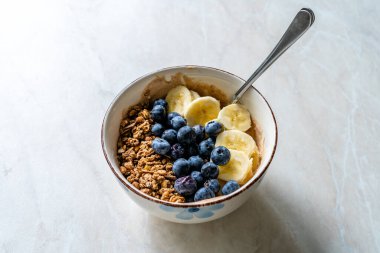 Yabanmersinli granola, muz ve fıstık ezmeli yoğurt veya yoğurt. Hizmet ve Yemeye Hazır.