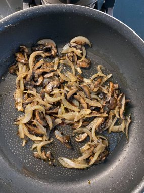 Tavada sotelenmiş mantar dilimleri ve soğan. Hizmet ve Yemeye Hazır.