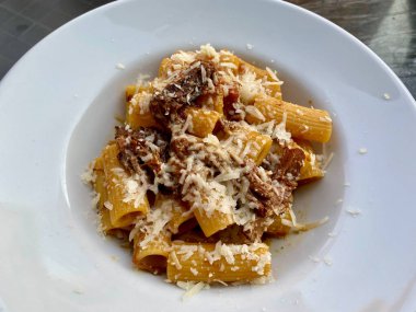 Rigatoni Pasta Alla Genovese, tipik bir Napoli tarifi. Parmesan peyniri, soğan ve et bir İtalyan restoranında. Geleneksel Tabak.