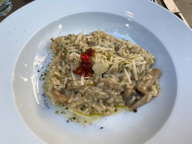 Restoranda servis edilen mantarlı ve kurutulmuş domatesli risotto. Yemeye hazır..