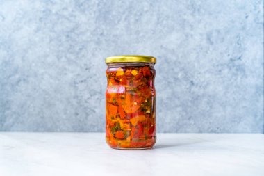 Cam kavanozda sarımsaklı sebzeli kızarmış kırmızı biber. Yemeye hazır..