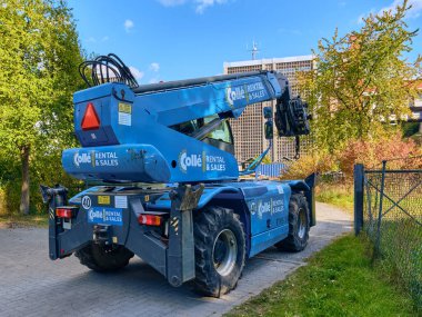 Winsen, Almanya; 30 Eylül 2025: Yeni HYTEC inşaat makineleri: Sanayi faaliyetlerini gösteren ithalat sahasında sergilenen, bir çatı altında küçük patinaj direksiyon yükleyicileri.