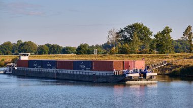 Scharnebeck, Almanya; 30 Eylül 2025: Elbe-Seitenkanal 'da gemi asansörünün yanında görülen kargoyla birlikte iç nakliye ve navigasyonu gösteren bir mavna itildi..