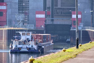 Scharnebeck, Almanya; 30 Eylül 2025: Sch 2334 numaralı itfaiye teknesinin Elbe-Seitenkanal 'da bir yük mavnasını, gemi asansörünün yanında çekerken görüntüsü ve seyrüsefer.