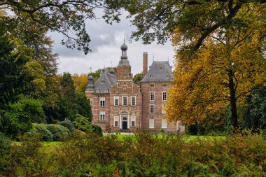 Laag Keppel, Hollanda; 17 Ekim 2025: Renkli sonbahar ağaçları tarafından çerçevelenmiş tarihi şato Laag Keppel, Hollanda Rönesans tuğlası mimarisi ve kırsal kesimde kültürel mirasın yer aldığı.