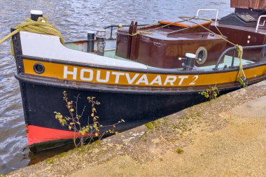İşçi, Hollanda; 26 Ekim 2025: Tarihsel römorkör Houtvaart 2 Zaan Nehri 'ne demirlemiş, fiyonk ve dökülen bitkilerin yakın görüntüsü, Hollanda sanayi ve deniz mirasının sembolü.