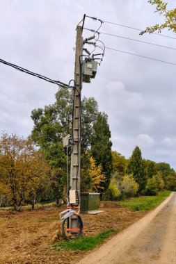 Saint-Ferreole-de-Comminges, Fransa; 1 Kasım 2025: Transformatör kutusuna bağlanan elektrik direği, modern kırsal elektrik şebekesinin gelişimini gösteriyor.