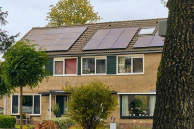 Norg, Hollanda; 9 Ekim 2025: 1970 'lerin tipik teraslı evleri, yenilenebilir enerji kullanımı ve konut mimarisini gösteren, farklı çatı katları olan bir köy genişleme alanı..