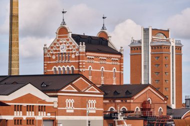 Ahus, İsveç 22 Eylül 2025: Mutlak Votka damıtma binaları ve sahil boyundaki Spiritkyrkan kulesi İsveç mirası endüstrisini ve modern liman faaliyetlerini gösteriyor.