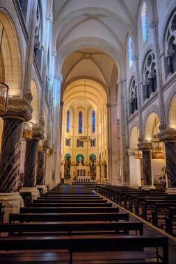 Fransa 'daki Lourdes' in Kutsal Yüreği Kilisesi 'nin iç manzarasında sıra sıra tahta kilise sıraları mermer kemerler ve vitray pencereler sergileniyor. Bu resim, dini seyahatleri resmetmek için uygundur.
