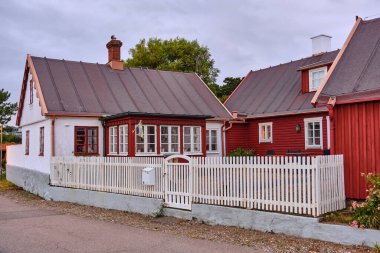 İsveç 'in Öresund kıyısı boyunca Helsingborg' a yakın Lard 'daki deniz kıyısındaki evlerde kırmızı ve beyaz binalar ve çitlerle çevrili bir İsveç köyünün özünü yansıtan görüntüler sergileniyor..