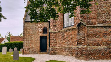 Walcheren Hollanda 'nın eski adası Gapinge' deki Mariakerk kilisesinin dış görünüşü. 15. yüzyıldan kalma, mezarlığı olan bu tuğla bina, Avrupa tarihi mimarisi ve dini mirasına bir göz atma olanağı sağlıyor..