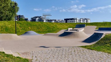 İsveç 'in Landskrona şehrinde çeşitli rampa ve engellerin yer aldığı bir kaykay parkı, modern binalar ve mavi gökyüzünün altında görülebilen yeşil çimlerle İsveç' te eğlence amaçlı aktiviteler ve şehir sporları için bir alan oluşturmaktadır..