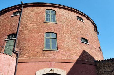 Landskrona, İsveç - 8 Ağustos 2025: Landskrona Kalesi 'nde pencereleri olan yuvarlak tuğla bina, İsveç' in eşsiz mimarisini sergileyen tarihi bir dönüm noktası ve turistik cazibesini temsil eden açık mavi bir gökyüzüne karşı duruyor..