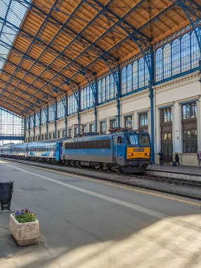 Budapeşte, Macaristan, 1 Mayıs 2025. Yolcu, Macaristan 'ın geleneksel demir ve cam mimarisi ile tarihi Budapeşte tren terminalinde tren kullanıyor. Yüksek kalite fotoğraf.