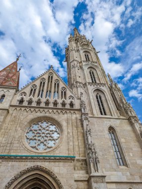 Budapeşte, Macaristan, 1 Mayıs 2025. Mavi gökyüzü Budapeşte 'sine karşı renkli kiremit çatılı ve gotik mimarisi olan Matthias kilise kulesi. Yüksek kalite fotoğraf.