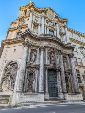 Roma, İtalya, Mayıs 01, 2025. Roma 'da klasik mimari unsurlar, heykeller ve İtalya' da geleneksel İtalyan dini yapı tasarımı ve simetrik kompozisyonu gösteren süslü detaylarla zarif bir barok kilise cephesi. Yüksek kalite fotoğraf