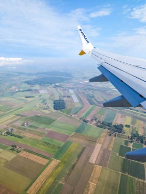 Varşova, Polonya, Mayıs 01, 2025. Gündüz uçuşu sırasında kırsal araziyi gösteren geometrik alan desenli tarımsal alan desenli uçak penceresinden hava perspektifi. Yüksek kalite fotoğraf