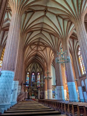 Varşova, Polonya, Mayıs 01, 2025. Huzurlu gotik katedral havzası, tırtıklı tavan, cam pencereler ve Varşova Polonya 'da sıralanmış tahta sıralar, ortaçağ kilisesinin içini gösteriyor. Yüksek kalite fotoğraf