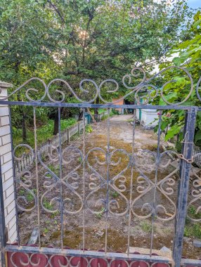 Decorative metal gate with ornamental patterns in Zhytomyr Ukraine showing traditional Ukrainian ironwork craftsmanship and residential entrance design. High quality photograph