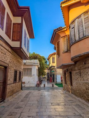 Antalya, Türkiye, 1 Mayıs 2025. Kaleici eski kenti Antalya Türkiye 'nin kaldırım taşı meydanında, kemerli girişi ve geleneksel mimarisi olan tarihi taş bina bulunuyor. Yüksek kalite fotoğraf