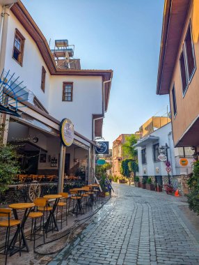Antalya, Turkey, May 01, 2025. Outdoor restaurant terrace with wooden furniture overlooks marina harbor in historic Kaleici old town of Antalya Turkey. High quality photograph