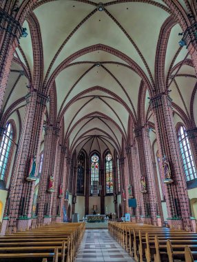 Katowice, Polonya, Mayıs 01, 2025. Gotik katedral iç mimarisi, katolik Polonya 'nın tarihi kilisesinde kemer ve ahşap sıralardan oluşan etkileyici kubbeli tavanlar gösteriyor. Yüksek kalite fotoğraf