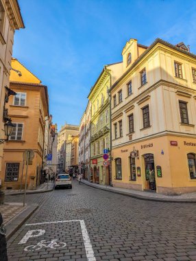 Prag, Çek Cumhuriyeti, 1 Mayıs 2025. Prag Çek Cumhuriyeti 'nin eski kasabasında sabah ışığında kaldırım taşı caddesi boyunca sarı barok binalar. Yüksek kalite fotoğraf