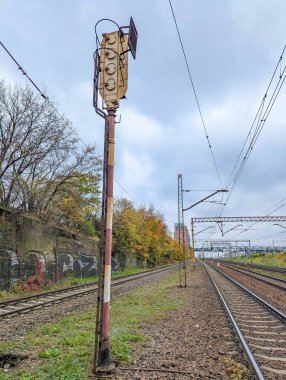 Varşova, Polonya, 20 Ekim 2025. Warszawska Kolej Dojazdowa WKD açık hava istasyonu Varşova Polonya 'da sonbahar ağaçları ve raylarıyla demiryolu işaret direği. Yüksek kalite fotoğraf