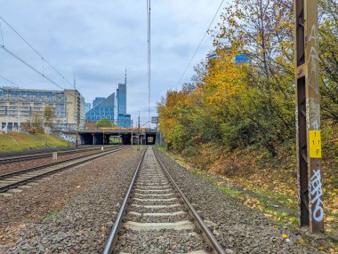 Varşova, Polonya, 20 Ekim 2025. Warszawska Kolej Dojazdowa WKD istasyonu Varşova Polonya 'da modern şehir binaları ve sonbahar ağaçları ile raylar. Yüksek kalite fotoğraf