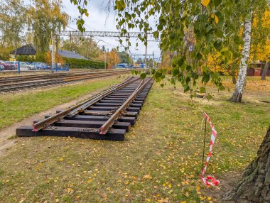 Varşova, Polonya, 20 Ekim 2025. Varşova WKD istasyonu Varşova Polonya 'da, Warszawska Kolej Dojazdowa' da sonbahar yeşillikleriyle çim üzerinde demiryolu bölümleri istiflenmiş. Yüksek kalite fotoğraf