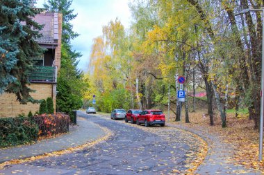 Varşova, Polonya, Mayıs 01, 2025. Varşova Polonya mahallesinde renkli sonbahar ağaçları ve park edilmiş kırmızı arabalarla dolu sessiz bir yerleşim yeri. Yüksek kalite fotoğraf.
