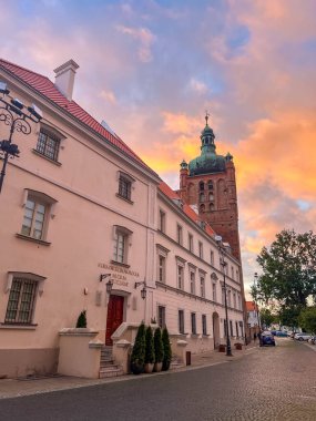 Plock, Polonya, Mayıs 01, 2025. Karanlık kuleye sahip tarihi beyaz bina eski şehir Plock Poland 'da gün batımı gökyüzüne karşı akşam saatinde. Yüksek kalite fotoğraf.