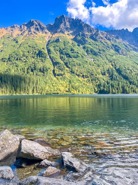 Kayalık kıyı ve Tatra dağları ile sakin alp gölü Zakopane Polonya yakınlarındaki sakin sulara yansıyor. Yüksek kalite fotoğraf.