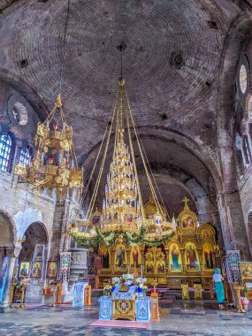 Brest, Belarus, 1 Mayıs 2025. Kristal avize ve dini tablolarla muhteşem altın barok sunağı Brest Belarus 'taki kubbeli kilisenin iç uzayını dolduruyor. Yüksek kalite fotoğraf.